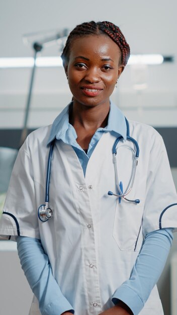 Портрет медицинского специалиста в белом халате и стетоскопе, стоящего в больничной палате. Женщина, работающая врачом, чтобы помочь людям с болезнями, смотрит в камеру. Врач здравоохранения