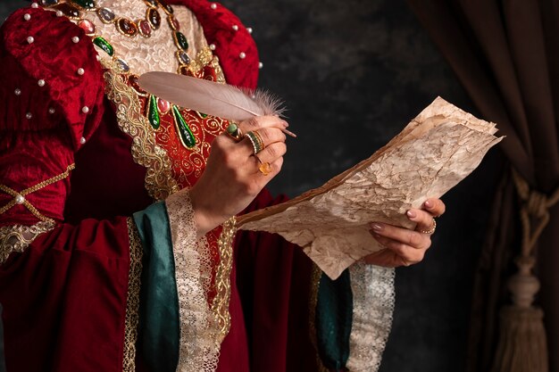 Portrait of medieval queen with quill writing on paper