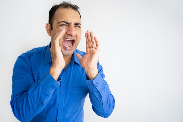 Portrait of mid adult businessman standing and shouting isolated