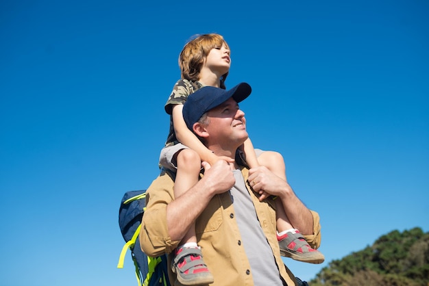 Portrait of mid adult man carrying son piggyback