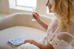 Free photo portrait of middle-aged blonde rich woman with champagne glass and banknotes