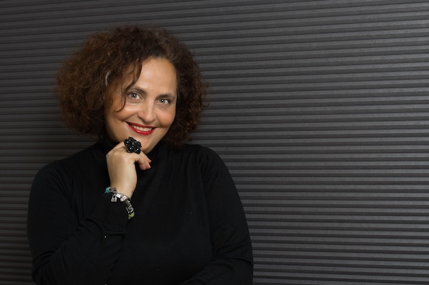 Portrait of a middle-aged Hispanic cheerful female with curly hair