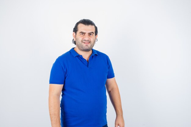 青いTシャツで正面を見て中年男性の肖像画