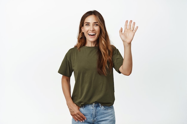 Portrait of middle aged mother, happy friendly woman waving hand, saying hello
