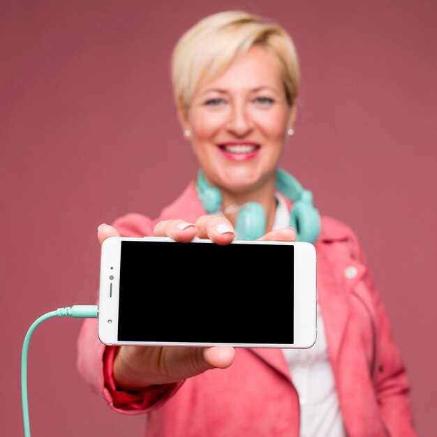 Портрет среднего возраста женщины, показывая шаблон смартфона