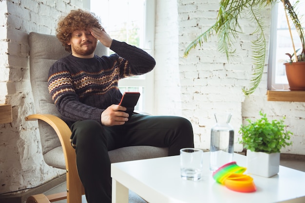 Portrait of millenial boy using retro toys, meeting things from the past and having fun