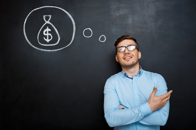 Free photo portrait of minded man crossed hands over blackboard money conc