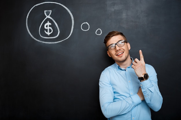 Portrait of minded man pointing on his mind about money