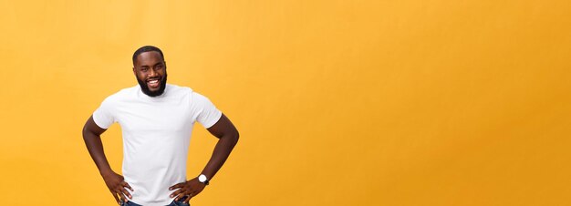 Portrait of a modern young black man smiling standing on isolated yellow background