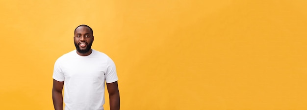 Portrait of a modern young black man smiling standing isolated yellow background