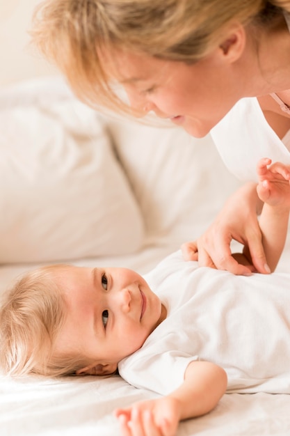 Portrait of mom and baby snuggling in bed