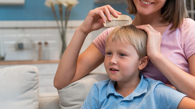 Portrait of mother arranging sons hair