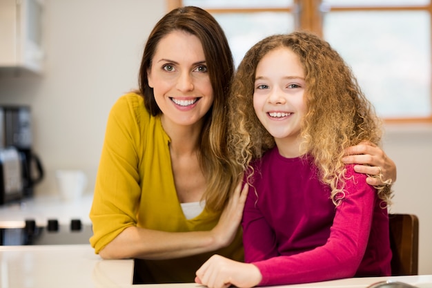 Portrait of mother and daughter in kitchen