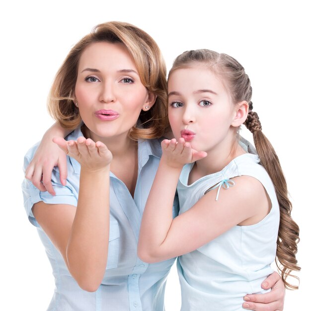 Portrait of mother and daughter send kisses - studio shot on white