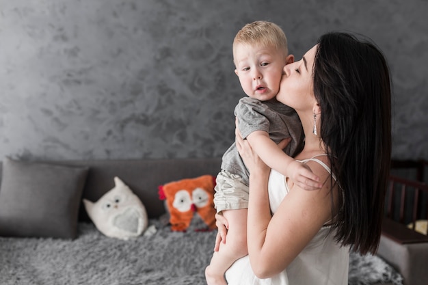 Free photo portrait of mother kissing her son