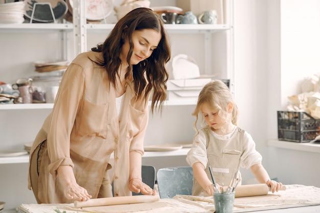 Free photo portrait of mother and little girl shaping clay together