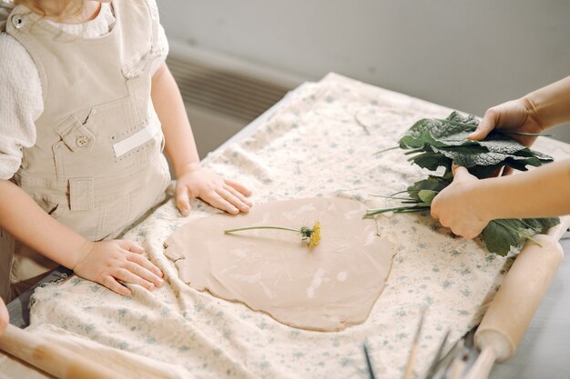 Portrait of mother and little girl shaping clay together