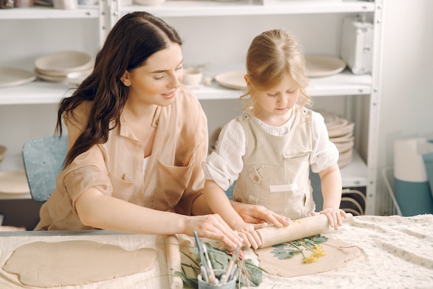 Portrait of mother and little girl shaping clay together