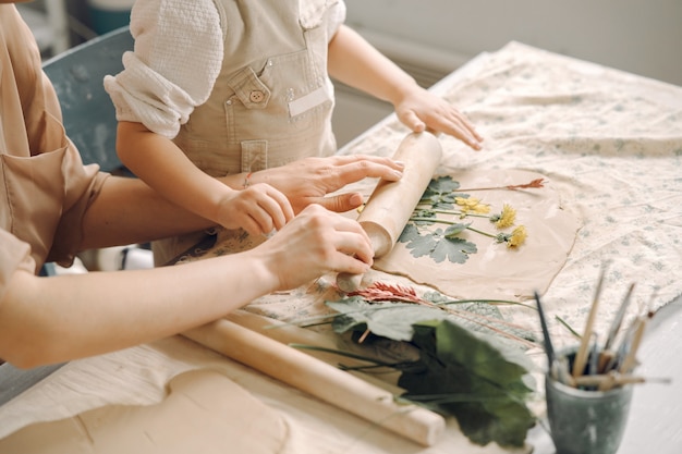 母と一緒に粘土を形作る少女の肖像画