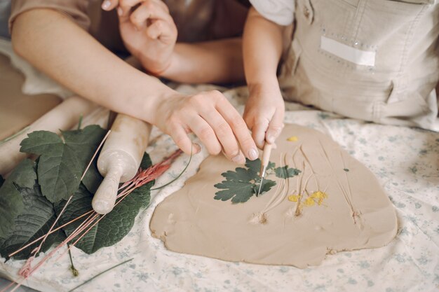 Portrait of mother and little girl shaping clay together