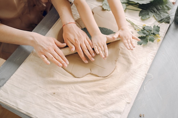 Portrait of mother and little girl shaping clay together