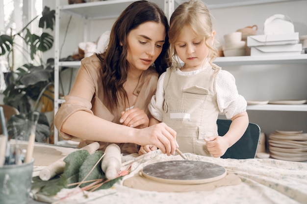 Portrait of mother and little girl shaping clay together