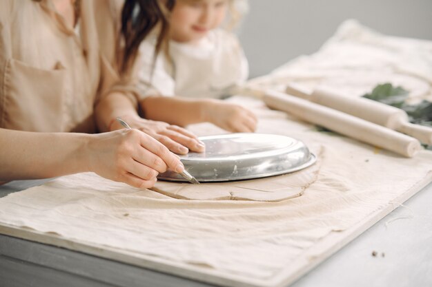 Portrait of mother and little girl shaping clay together