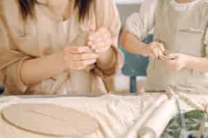 Free photo portrait of mother and little girl shaping clay together