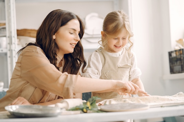 Portrait of mother and little girl shaping clay together