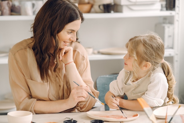 Portrait of mother and little girl shaping clay together