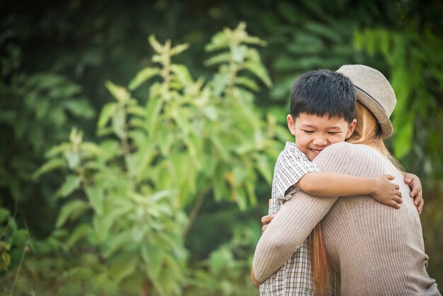 Portrait of mother and son happy cuddle together in the park. Family concept.