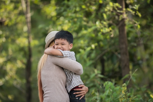 Portrait of mother and son happy cuddle together in the park. Family concept.