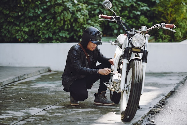 Free photo portrait of motorcyclist preparing his vehicle for a ride