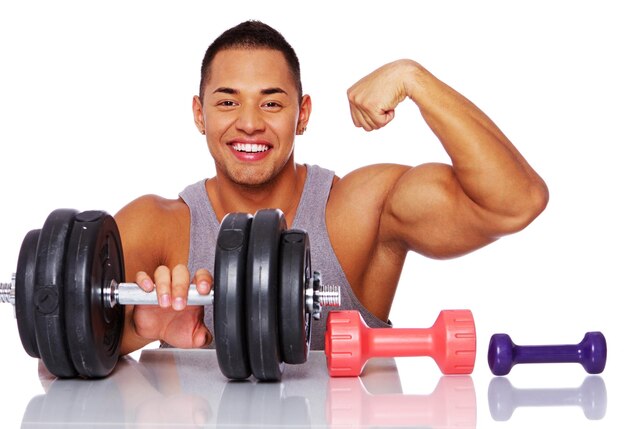 Portrait of muscle man posing in studio with dumbbells