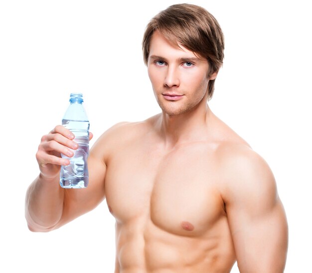 Portrait of muscular shirtless sportsman holds water - isolated on white wall.
