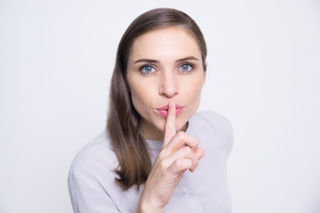 Portrait of mysterious woman holding finger on lip