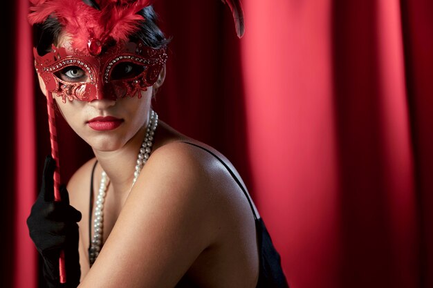 Portrait of mysterious woman with carnival mask