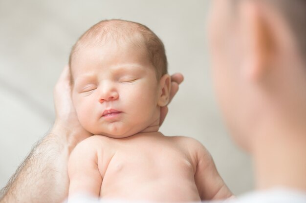 Portrait of a newborn hold in father palms