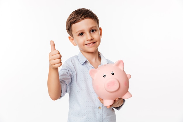 Portrait of a nice cute little kid holding piggy bank