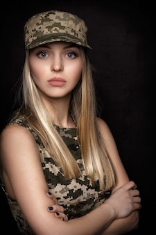 Портрет красивой белокурой женщины-солдата в военной форме на черном фоне