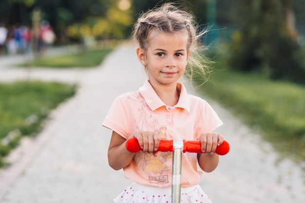 公園のプッシュスクーターの女の子の肖像画