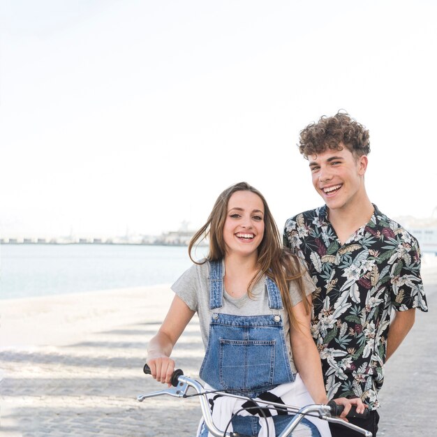 무료 사진 카메라를보고 자전거와 함께 행복한 커플의 초상화