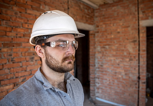 Бесплатное фото Портрет мужчины-строителя на строительной площадке.