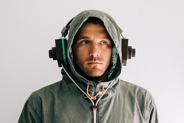 パーカーを着て 木製のヘッドフォンで音楽を聴く人の肖像画 プレミアム写真