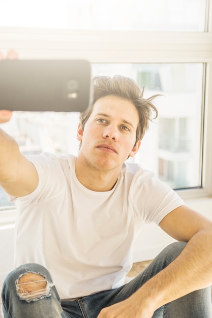 Бесплатное фото Портрет мужчины, занимающегося самоубийством с помощью смартфона
