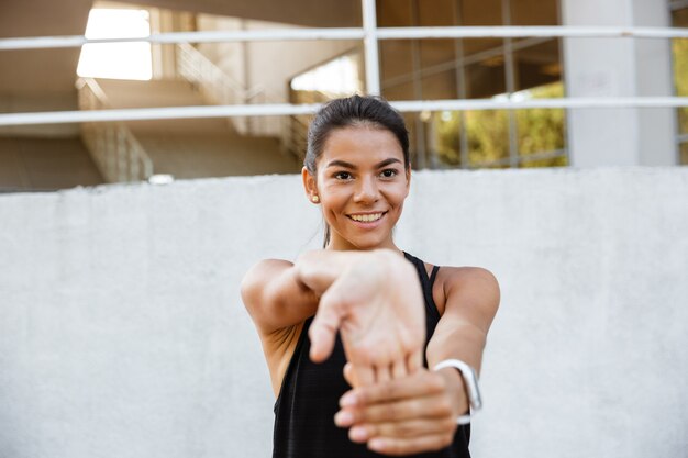 Бесплатное фото Портрет улыбающегося фитнес женщины протягивая руки