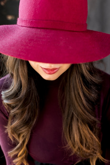 무료 사진 그녀의 눈을 덮고 분홍색 모자에있는 여자의 초상화
