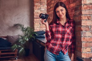 portrait of a young female photographer in a flannel shirt and j