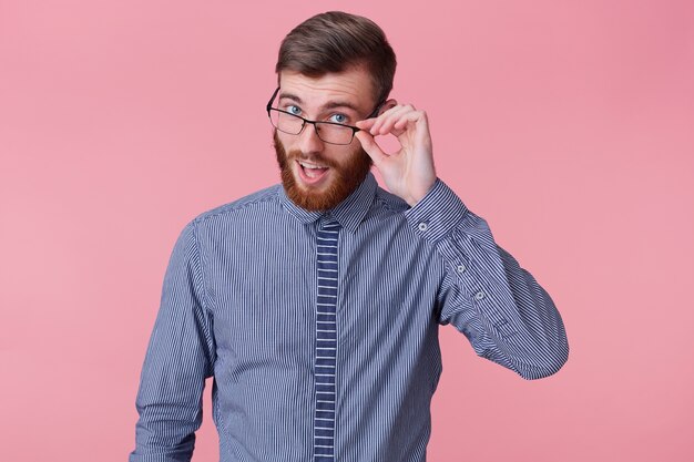 クローズアップうれしそうなポジティブな笑顔の魅力的な若い赤毛の女性そばかすのにきびが頭を傾けて笑うのんきな赤面顔を隠すニヤリと面白い話の冗談を聞く 白い背景に立っている 無料の写真