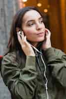 Бесплатное фото Портрет молодой женщины прослушивания музыки на наушники
